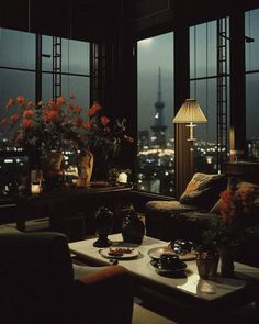 a living room filled with lots of furniture and flowers on top of a coffee table