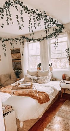 an unmade bed in a bedroom with lots of greenery on the ceiling and windows