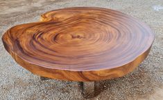 a wooden table sitting on top of gravel covered ground