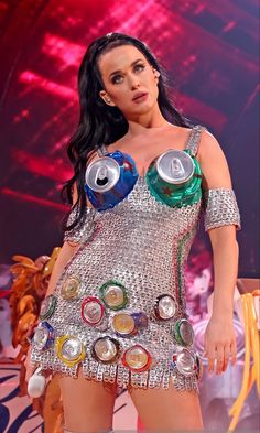 a woman in a silver dress with cans on her chest