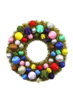 a christmas wreath with multicolored balls and tinsel on it, against a white background