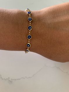 This 14K Gold Evil Eye Bracelet is an ideal accessory for daily wear, crafted from 14K solid gold with a glass blue eye. Make a lasting impression with the perfect gift for yourself or a loved one. The bracelet is available in a classic blue shade, delivering an iconic look. ♦ Materials: 14K Yellow God, Glass Blue Eye ♦ Available color: Blue evil eye ♦ Bracelet Measurements: Bracelet is 6 MM thick and 7.5" length, average weight 7.2grams, it does have a lobster clasp not a spring ring----------- Hypoallergenic Gold Plated Blue Jewelry, Hypoallergenic Blue Gold-plated Jewelry, Everyday Blue Tarnish-resistant Jewelry, Blue Round Evil Eye Bracelets, Blue Evil Eye Round Bracelets, Blue 14k Gold Everyday Bracelets, Blue Round Gold Bracelet For Gift, Everyday Blue 14k Gold Bracelets, Adjustable Blue Gold-plated Jewelry