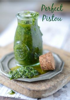 a glass jar filled with green liquid next to a cork on top of a plate