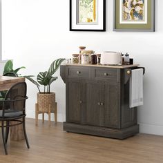 a kitchen area with a table, chair and potted plant on the sideboard