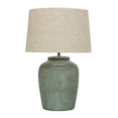 a green ceramic lamp with a beige linen shade on the base and a white fabric lampshade