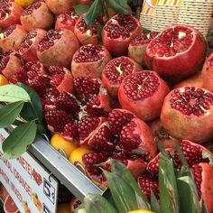 pomegranates and oranges are on display at a market for sale