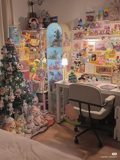 a room with a christmas tree and many stuffed animals on the walls, along with a computer desk