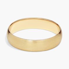 a yellow gold wedding ring on a white background