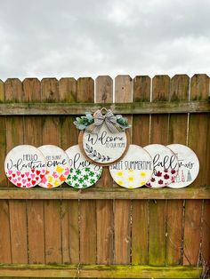 three wooden signs are hanging on a fence