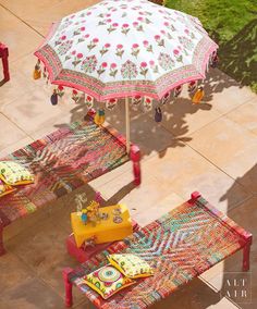 an umbrella and two benches on the ground