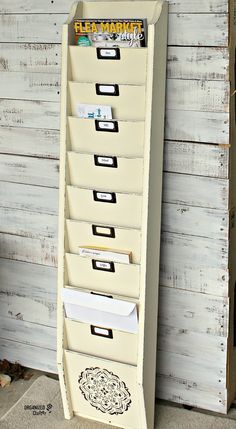 a white filing cabinet with five drawers on the bottom and four file folders on top