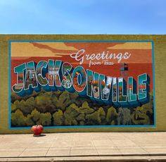 a mural on the side of a building that says jacksonville, with trees and mountains in the background