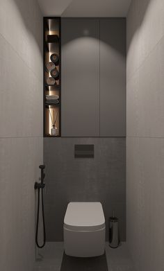 a bathroom with a white toilet sitting next to a wall mounted faucet in front of it