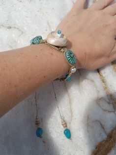 Beautiful Natural Shell Hemp Macrame Bracelet, Macrame Shell Turquoise Boho Bracelet, upcycled paper bead shell adjustable bracelet, beach boho chic... For this beautiful spiral Seashell hemp Macrame beaded Bracelet, I used a unique mix of media... This is a one-of-a-kind jewelry piece. . .. A spiral sea shell that I found on the beach here in Santa Cruz, California is woven into hemp macrame cord with genuine Kingsman turquoise, hand made and laquered (upcycled calendar) paper art beads, vintage glass teal seashell beads and pearlized white beads. I wove all of them together by hand knotting hemp into this adjustable macrame bracelet.  Lanyard style closure will slide to adjust to fit most wrists. At its smallest it measures 7.5 inches long, and at its largest it measures 10 inches. Very Bohemian Hand Wrapped Turquoise Braided Bracelets, Bohemian Turquoise Hand Wrapped Braided Bracelets, Bohemian Turquoise Hand-wrapped Braided Bracelets, Bohemian Turquoise Braided Bracelets, Turquoise Bohemian Strand Friendship Bracelets, Artisan Hand Wrapped Beaded Bracelets For Beach, Blue Bohemian Braided Bracelets For Beach, Blue Bohemian Braided Bracelet For Beach, Hippie Turquoise Friendship Bracelets For Beach