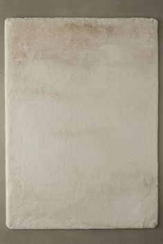 a white square rug on a wall