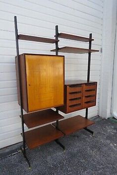 three shelves and two drawers in front of a white garage door, with one shelf open to the side