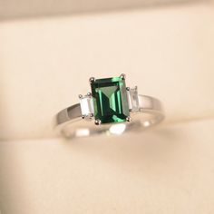 This ring features a (6*8 mm emerald cut green sapphire). Customization is available. It is made by hand, and it will take about 7 days to finish the ring after your payment is completed. Main stone: 6*8mm emerald cut Main stone weight:1.70ct Metal type: sterling silver finished with rhodium/14k gold Accent stone: CZ Customization is available, I also can make it with 14k solid gold (white or yellow or rose) and diamond accent stone, just feel free to contact me. Any question, just let me know. Unique Silver Rings, Green Sapphire Ring, Silver Wedding Ring, Green Sapphire, Gold Accent, Green Emerald, Eclectic Decor, Silver Wedding, Ring Sterling Silver