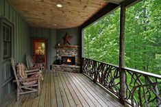 a porch with rocking chairs and a fire place