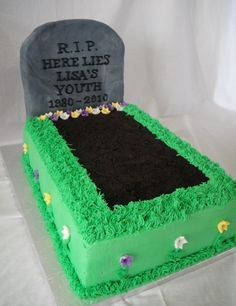 a grave cake with grass and flowers on it