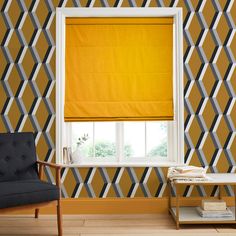 a living room with yellow and grey wallpaper, a gray chair and a window