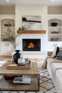 a living room filled with furniture and a fire place in the middle of the room