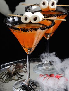 two halloween cocktails with spooky eyes and marshmallow eyeballs on the rim