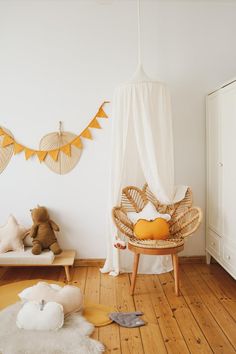 a baby's room with white walls and wooden flooring is decorated in neutral colors