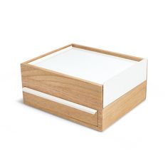 an empty wooden box with white sheets on the top and bottom, sitting on a white surface