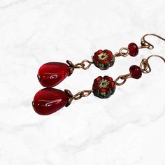 Cherry red dangle earrings in copper. These exquisite flower earrings are handcrafted using high-quality Czech glass beads. The vibrant ruby red jewel color adds a pop of festivity, making them perfect for celebrations or any special occasion.  With their Bohemian flair, these earrings effortlessly elevate your style. The long length is both elegant and eye-catching, making a bold statement wherever you go.  Add a touch of Boho chic to your look with these gorgeous red beaded earrings. - Hypoall Red Beaded Earrings, Red Bead Earrings, Necklaces Boho, Bohemian Flower, Winter Earrings, Glass Bead Earrings, Red Jewel, Earrings Hypoallergenic, Bohemian Flowers