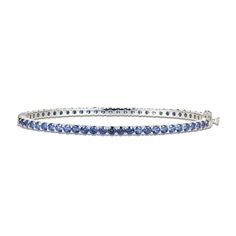 Gorgeous round blue lab-created sapphires adorn this sophisticated bangle fashioned in classic sterling silver. The bracelet measures 7.25 inches and secures with a box clasp. Classic Gemstone Bangle For Anniversary, Blue Fine Jewelry Bangle For Gifts, Timeless Blue Bracelet For Formal Occasions, Fine Jewelry Sapphire Bangle Bracelet, Fine Jewelry Sapphire Bracelets, Elegant Blue Stackable Jewelry, Classic Blue Stackable Jewelry, Sapphire Tennis Bracelet With 17 Jewels, Silver Sapphire Tennis Bracelet