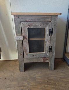 an old wooden cabinet sitting on top of a hard wood floor next to a wall