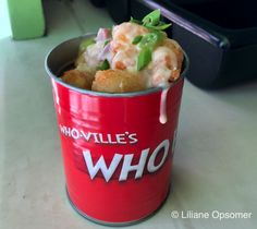 a red bucket filled with food sitting on top of a table