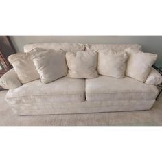 a white couch with lots of pillows on it