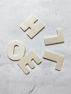 four wooden letters spelling out the word fo on a white surface with one letter cut out