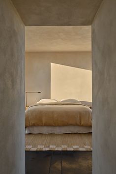 a bed sitting in the middle of a bedroom next to a doorway that leads into another room