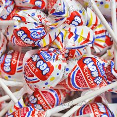 a pile of white and red lollipops with sprinkles on them