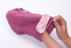 a person holding a pink towel with a bow on it