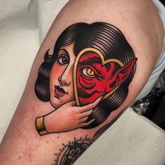 a woman's arm with a tattoo on it and a red demon in the middle