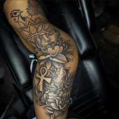 a woman's leg with tattoos and flowers on it