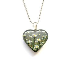 Daisy April Birth Flower Heart Pendant from the Painted Botanicals Collection - a range of hand painted jewellery and accessories featuring the magic of flowers! A cute and very wearable mini heart pendant for April birthdays - or anyone who loves daisies! This would also make a lovely accessory for a bridesmaid wearing grey or silver. The design features tiny hand painted daisies in grass- set against a muted grey background. Tiny flecks of glitter add some extra sparkle to catch the light. The Painted Jewellery, Painted Daisies, Custom Hang Tags, April Birth Flower, Daisy Painting, Birthstone Colors, Hand Painted Jewelry, Custom Tags, Tiny Hand