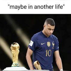 a man standing next to a golden trophy