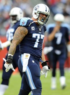 a football player is walking on the field with his hands in his pockets and wearing gloves