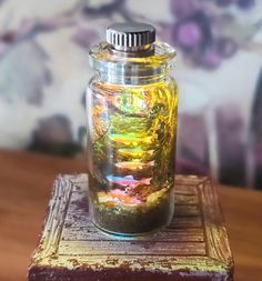 a glass jar sitting on top of a wooden block