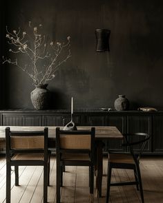 a dining room table with two chairs and a vase