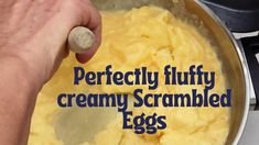 a person mixing eggs in a pan with the words perfectly fluffy creamy scrambled eggs