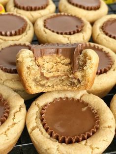 peanut butter cupcakes with chocolate frosting and candy in the middle on a cooling rack