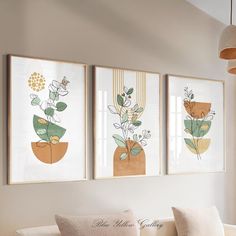 three framed art prints hanging on the wall above a couch