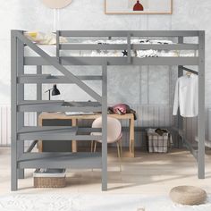 a loft bed with desk underneath it in a room that has white walls and wood flooring