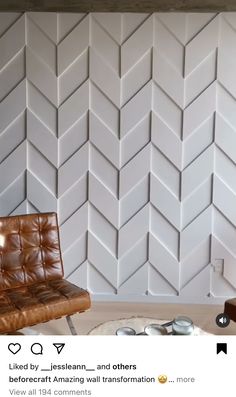 a brown leather chair sitting in front of a wall with white chevron tiles on it