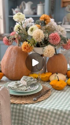 a table with flowers and pumpkins on it